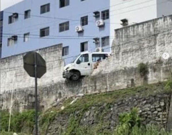 Motorista perde controle e van fica pendurada em muro de estacionamento em João Pessoa