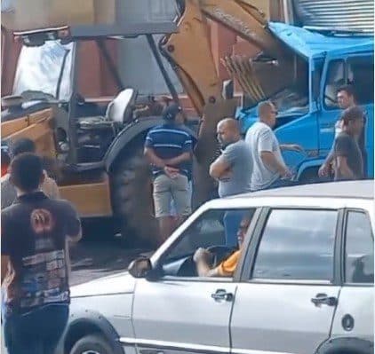 Caminhão bate em retroescavadeira, fica destruído e motorista escapa de ser atingido