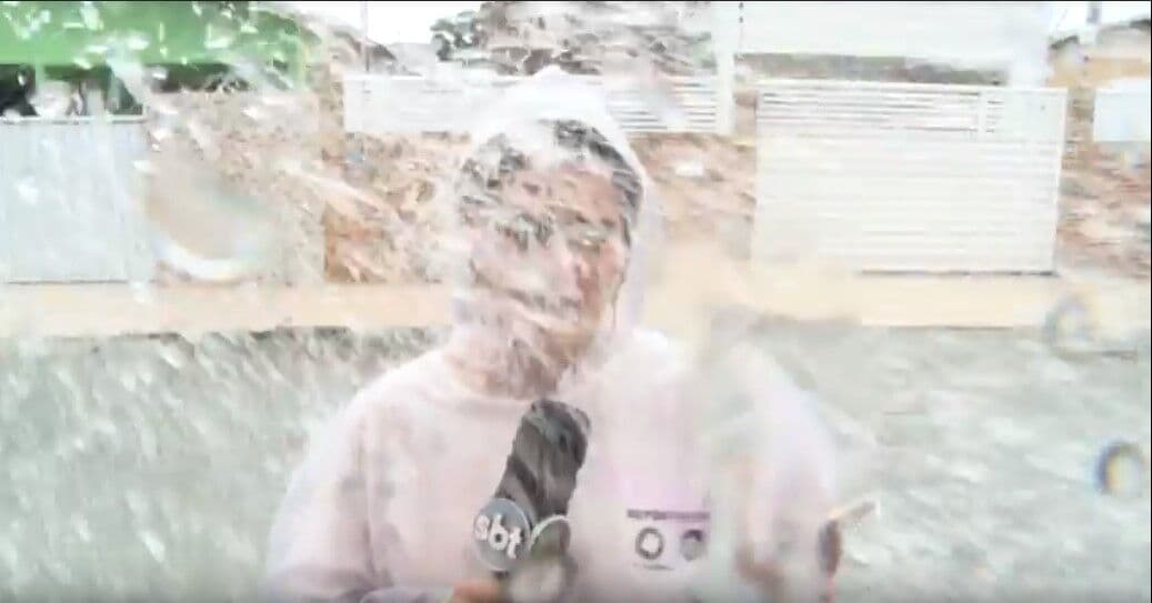 Carro passa em velocidade e joga água em repórter de TV que estava ao vivo