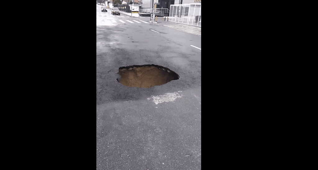 Buraco onde carro já foi 'engolido' em avenida da Capital reabre após chuvas e via é interditada