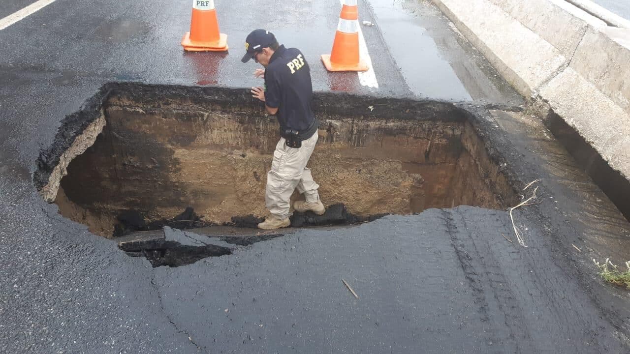 Asfalto cede e cratera se abre na cabeceira da ponte do Rio Paraíba